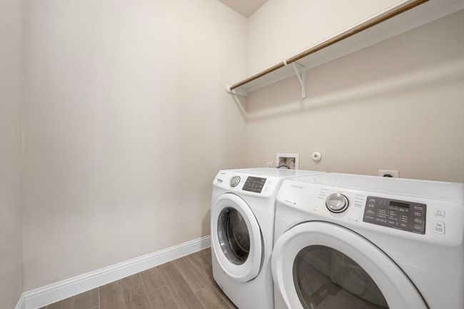 Laundry area featuring washer and dryer, baseboards, and light wood-style floors | Image 18