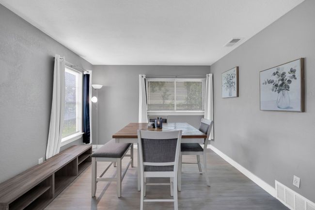 Dining area with wood finished floors, baseboards, and visible vents | Image 10