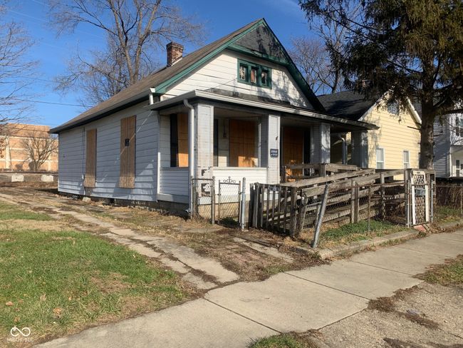 view of front facade with a gate, a fenced front yard, a chimney, and covered porch | Image 6