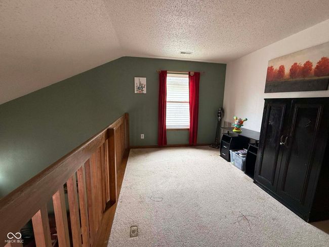 bonus room with vaulted ceiling, a textured ceiling, and light colored carpet | Image 20