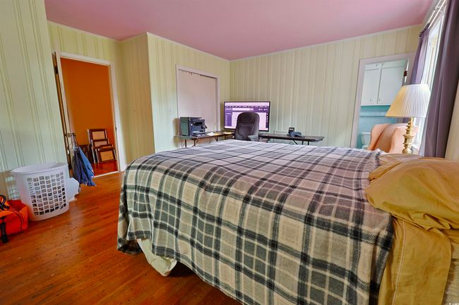 Bedroom featuring wood finished floors and wallpapered walls | Image 11