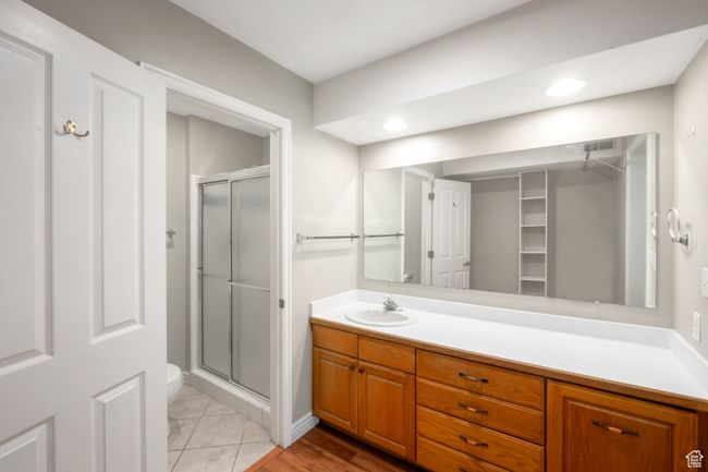 Full bath featuring a stall shower, vanity, a spacious closet, and recessed lighting | Image 12