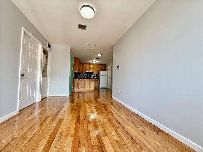 Unfurnished living room with baseboards and light wood-style flooring | Image 13