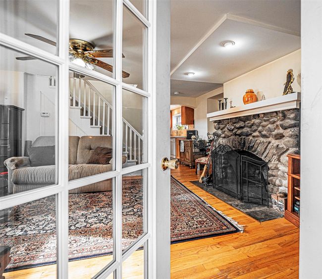 Living room with hardwood / wood-style flooring, ceiling fan, and a fireplace | Image 6