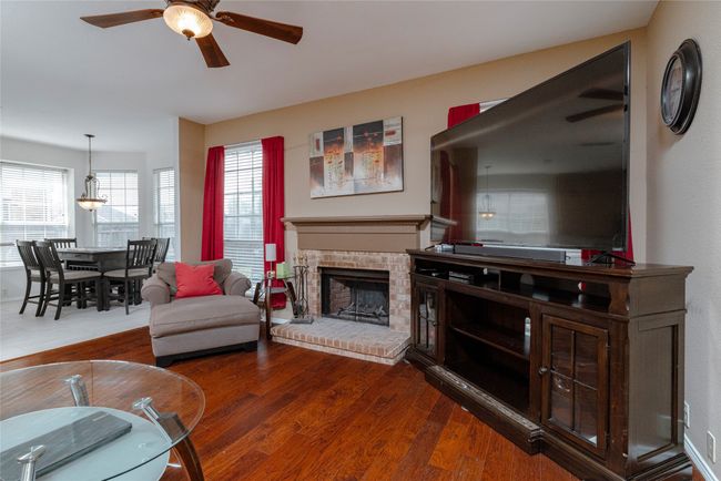 Living area featuring a ceiling fan, a fireplace, and wood finished floors | Image 11