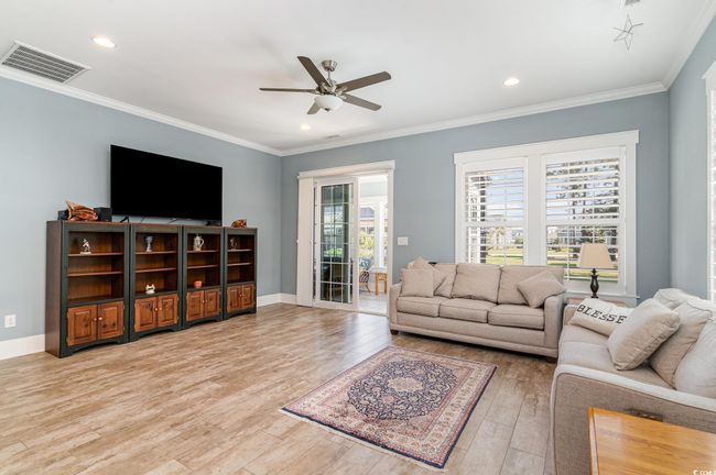 Living room with recessed lighting, visible vents, a ceiling fan, ornamental molding, and light wood-style flooring | Image 11
