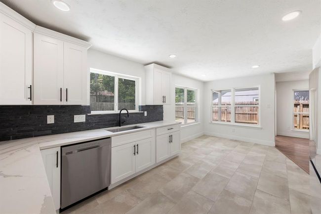 Expansive kitchen includes breakfast room surrounded by natural light and open to den for casual living space. | Image 11