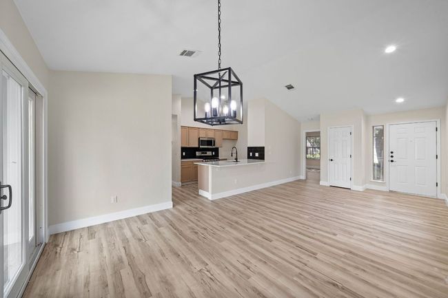 Unfurnished living room with light wood-style flooring, a chandelier, and recessed lighting | Image 11