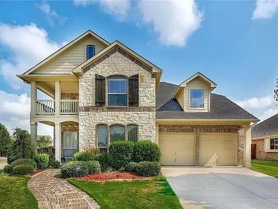 View of front of home with a balcony, a front yard, and a garage | Image 1