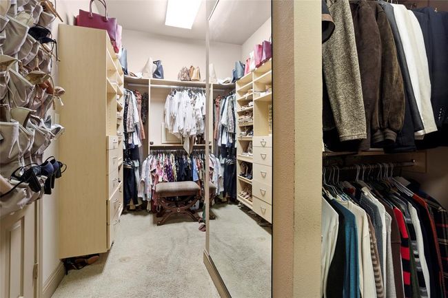 Large walk in closet separated by his/hers with a large dressing mirror.Custom built ins on both sides. | Image 19