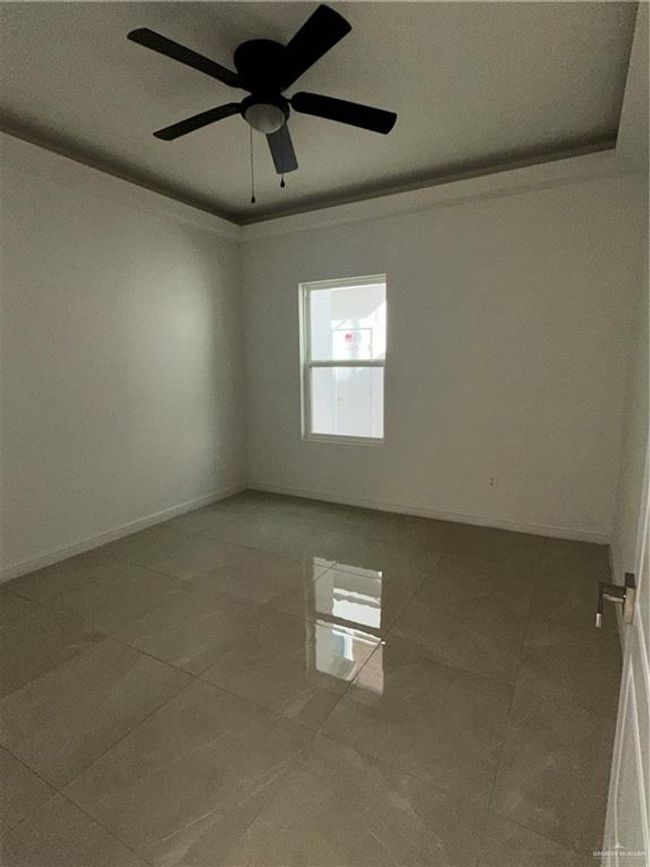 Spare room with crown molding, a ceiling fan, and baseboards | Image 8