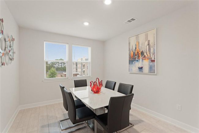 Bright dining with large windows offer natural light and a pleasant view. | Image 10