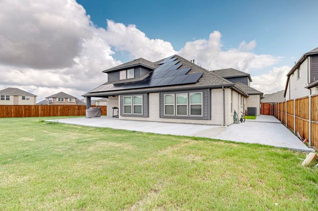 Back of house with roof with shingles, a fenced backyard, a patio area, brick siding, and a lawn | Image 38