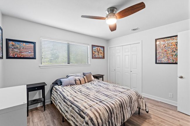 Bedroom with baseboards, wood finished floors, visible vents, and a closet | Image 21