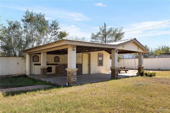 Back of property featuring an outdoor bar, a lawn, and a patio | Image 13
