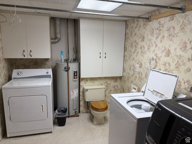 Washroom with electric water heater, washer and dryer, wallpapered walls, and light flooring | Image 17
