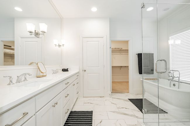 Bathroom with a spacious closet, a soaking tub, recessed lighting, vanity, and marble finish floor | Image 21