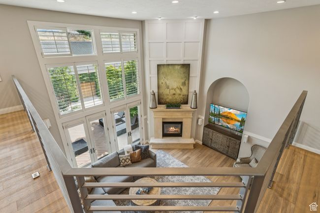 Living room with a high ceiling, a fireplace, recessed lighting, and wood finished floors | Image 39
