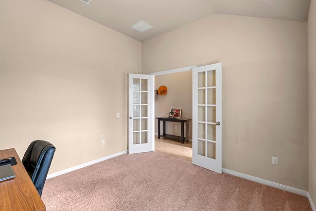 Unfurnished office with baseboards, french doors, carpet flooring, and vaulted ceiling | Image 6