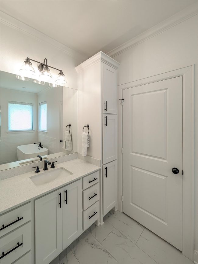 Full bathroom featuring vanity, ornamental molding, marble finish floors, and a freestanding bath | Image 22