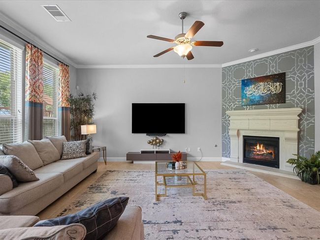 This spacious living room features large windows with beautiful water views, cozy fireplace and ceiling fans offer a warm and inviting atmosphere. | Image 14