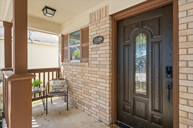 Entrance to property featuring covered porch and brick siding | Image 7