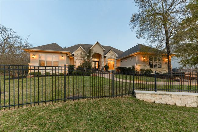 Ranch-style home with a front yard, a fenced front yard, stone siding, and stucco siding | Image 34
