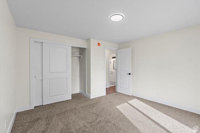 Unfurnished bedroom featuring carpet flooring, baseboards, and a closet | Image 15