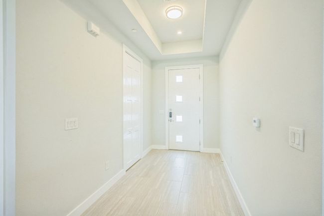 Doorway with baseboards and a tray ceiling | Image 8