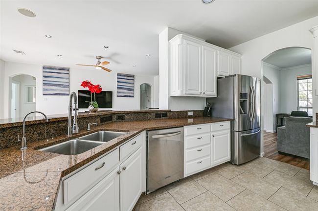Kitchen featuring light hardwood / wood-style flooring, crown molding, sink, white cabinets, and appliances with stainless steel finishes | Image 11