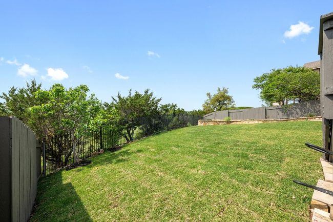 A large, gently sloping backyard provides endless possibilities—create your dream outdoor oasis, add a playset, or design a custom fire pit area for cool Texas evenings. | Image 31