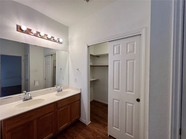 Bathroom with wood finished floors, double vanity, and baseboards | Image 9