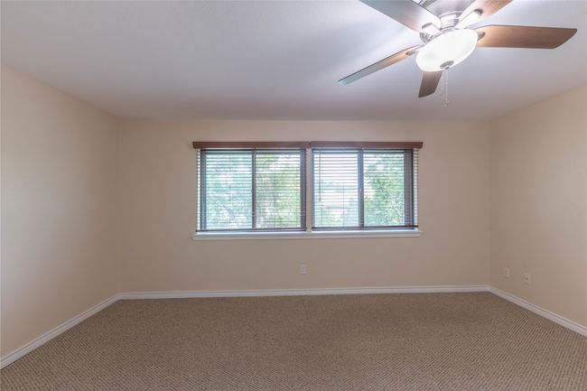 Carpeted spare room with baseboards and a ceiling fan | Image 16