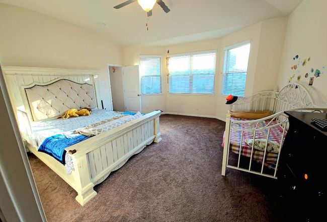Carpeted bedroom featuring multiple windows, lofted ceiling, and ceiling fan | Image 14