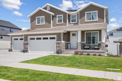 Craftsman inspired home featuring a front yard, a garage, and solar panels | Image 1