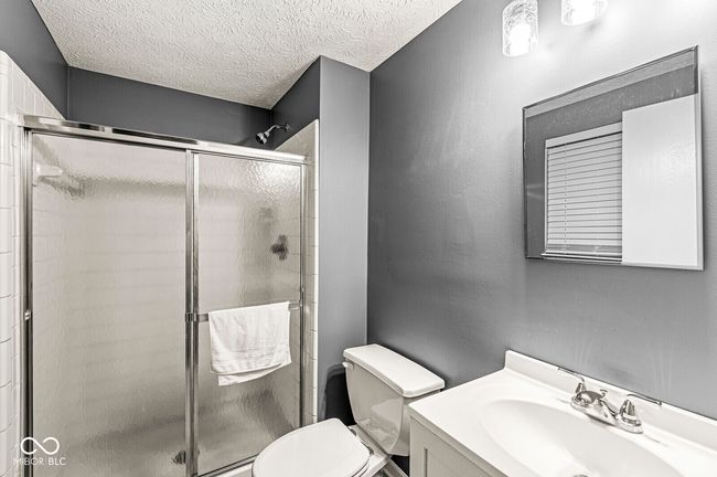 full bathroom featuring vanity, a stall shower, and a textured ceiling | Image 22