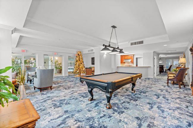 Rec room featuring a raised ceiling, carpet flooring, billiards table, and crown molding | Image 32