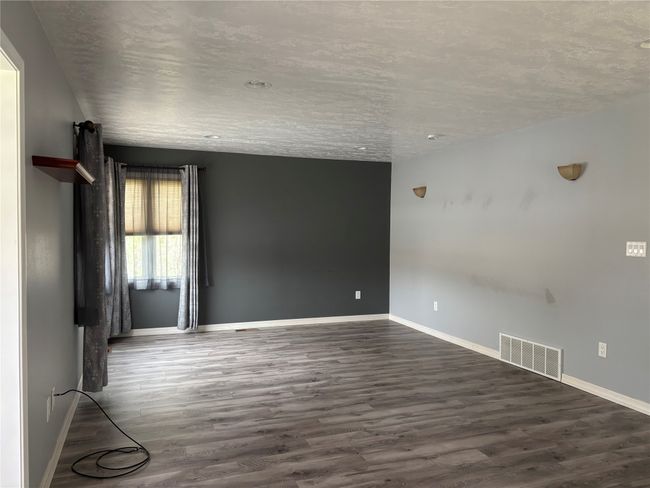 Unfurnished room with dark wood-style floors and baseboards | Image 5