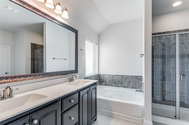 Bathroom with tile patterned floors, vanity, shower with separate bathtub, and vaulted ceiling | Image 24