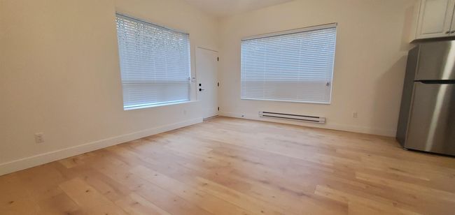 Unfurnished dining area with light wood-style floors, baseboards, and a baseboard radiator | Image 34