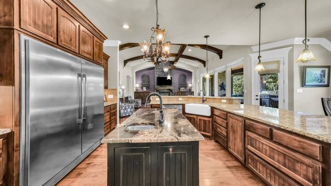 Kitchen with stainless steel built in refrigerator, arched walkways, lofted ceiling, light wood-style flooring, and recessed lighting | Image 22