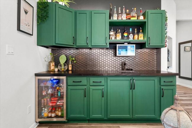 Bar featuring tasteful backsplash, light wood finished floors, wine cooler, and wet bar | Image 15