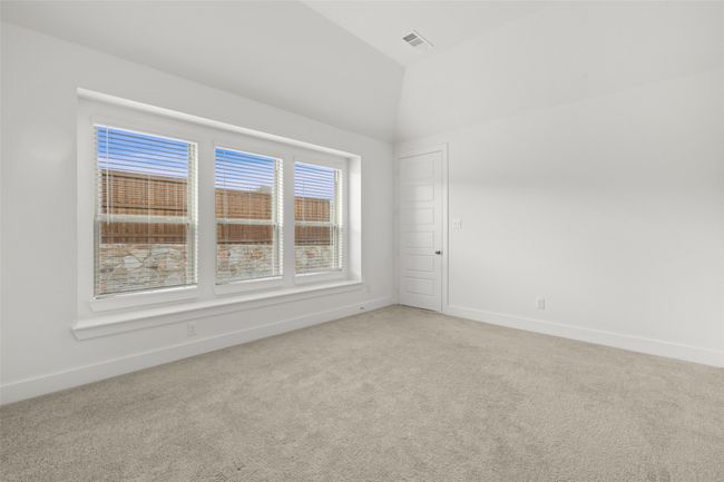 Empty room featuring light carpet, baseboards, vaulted ceiling, and visible vents | Image 23