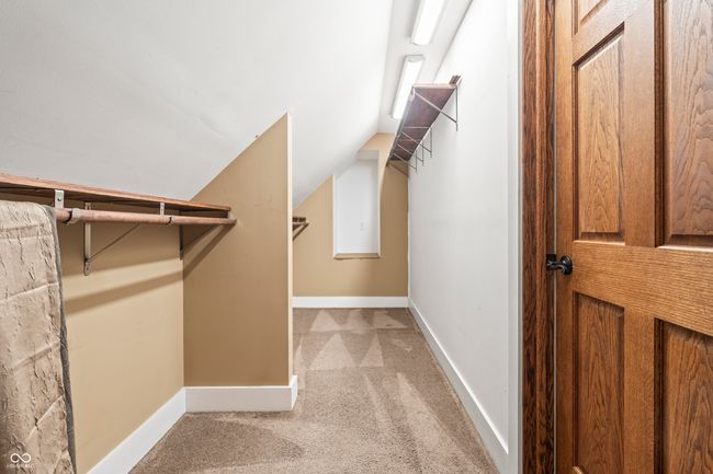 walk in closet with light carpet and vaulted ceiling | Image 35