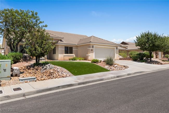 Ranch-style home with a tiled roof, a garage, driveway, stucco siding, and a front lawn | Image 46