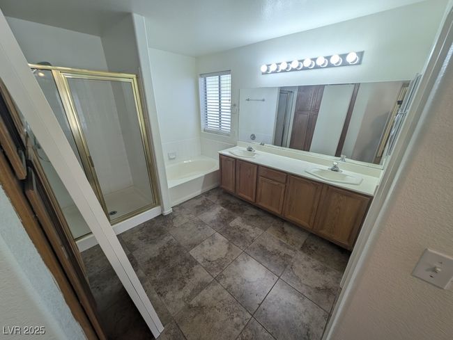 Bathroom with a garden tub, a stall shower, double vanity, and a sink | Image 12