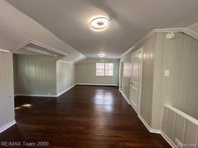 Bonus room with dark wood-style floors, lofted ceiling, and a baseboard radiator | Image 22