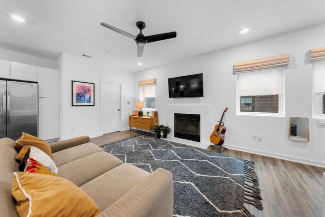 Living area featuring visible vents, a fireplace, wood finished floors, recessed lighting, and a ceiling fan | Image 8
