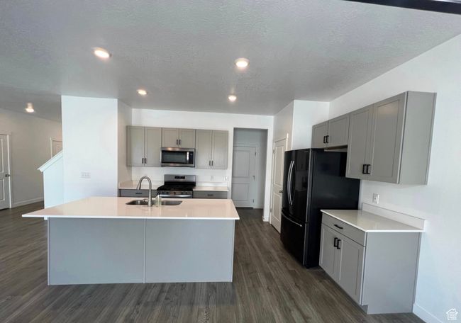 Kitchen with stainless steel appliances, gray cabinets, dark wood-type flooring, a textured ceiling, and recessed lighting | Image 7