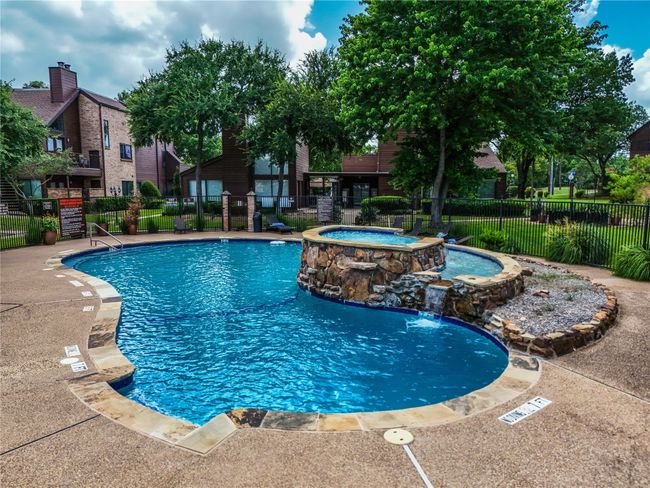 Sparkling community pool with a waterfall and hot tub | Image 23